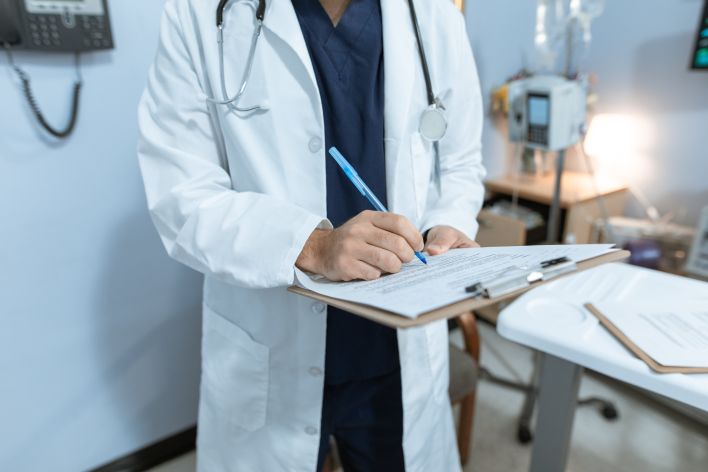 Doctor Writing on a Medical Chart